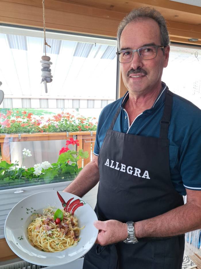 Angelo Marinelli (66) ist in Malè, Val di Sole (Italien) geboren und aufgewachsen. Seit rund vierzig Jahren lebt er mit seiner Familie in Müstair, aber seine Vorliebe für die italienische Küche ist geblieben. Angelo ist ein Vollblut «Nonno» von zwei kleinen Enkelbuben, aber auch ein leidenschaftlicher E-Bikefahrer. Mit dem E-Bike auf Tour geniesst er die Freiheit und Naturschönheiten seiner zweiten Heimat