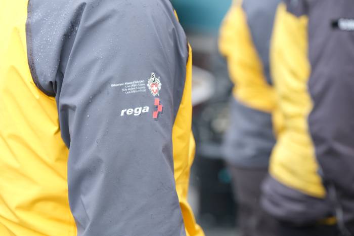 Die Retterinnen und Retter sind erkennbar an der gelben Jacke mit den Logos von Rega und Schweizer Alpenclub auf dem Ärmel.