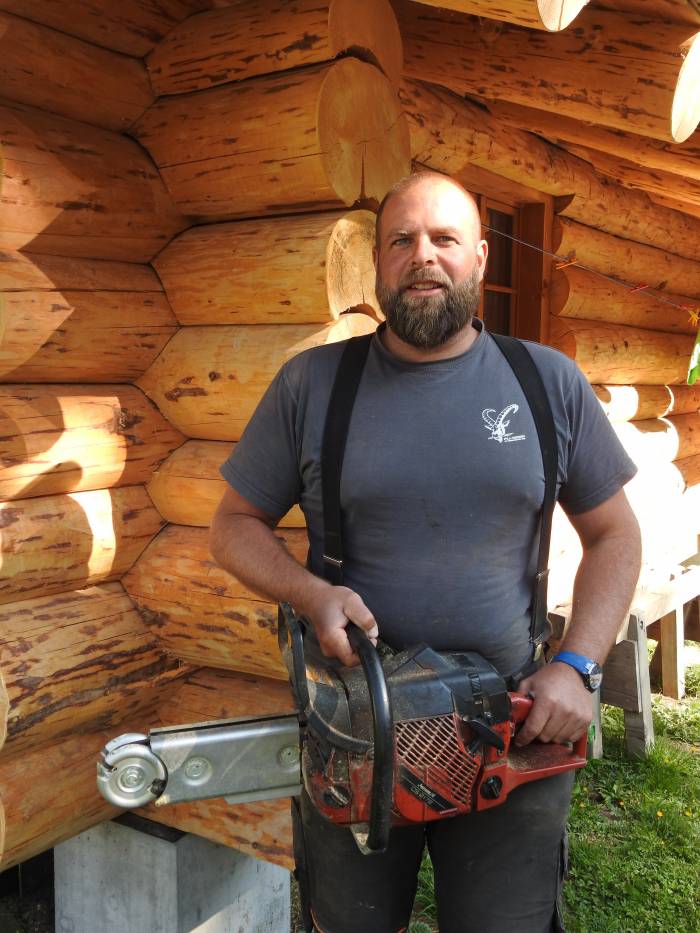 Jon Fadri Carpanetti vor seinem selbst gebauten Blockhaus.