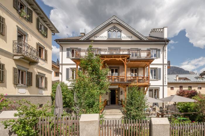 Das Aldier war immer ein Hotel, seit 1865. Ein besonderes Merkmal ist der schöne hölzernen Balkonvorbau an der frischen weiss gekalkten Fassade.