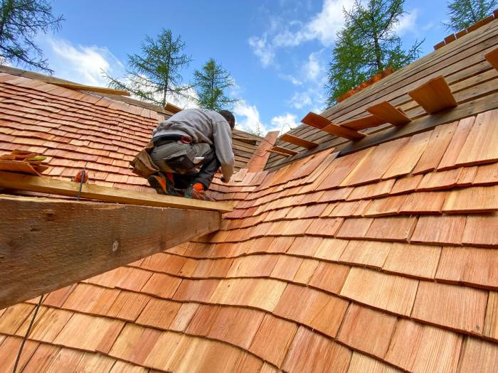 Mit von Hand gefertigten und genagelten Lärchenschindeln kommt altes Handwerk auf das Dach.