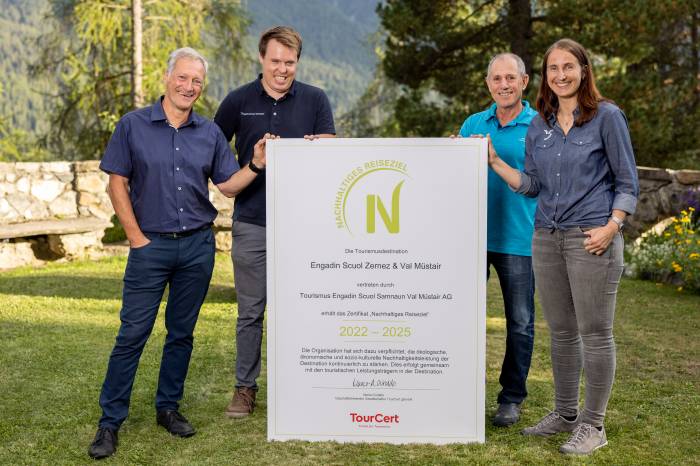 Urs Wagenseil (Hochschule Luzern und Zertifizierungsrat TourCert) übergibt die Zertifizierung «Nachhaltiges Reiseziel» an Sven Berchtold, Ludwig Jenal und Martina Hollenstein Stadler (alle TESSVM)